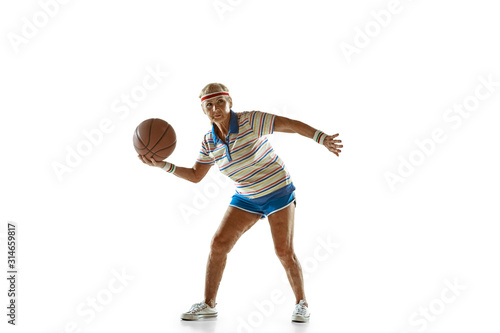 Energy. Senior woman wearing sportwear playing basketball on white background. Caucasian female model in great shape stays active. Concept of sport, activity, movement, wellbeing, confidence © master1305