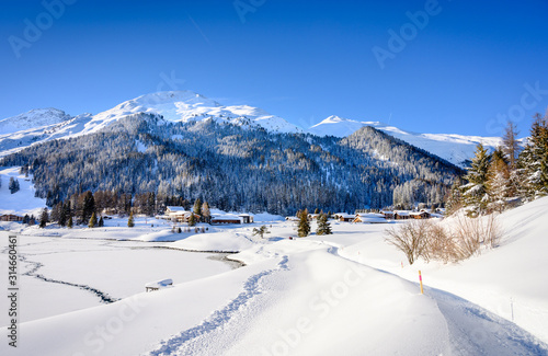 Landscape of lake Davos, covered by ice, in winter resort Davos, Switzerland.