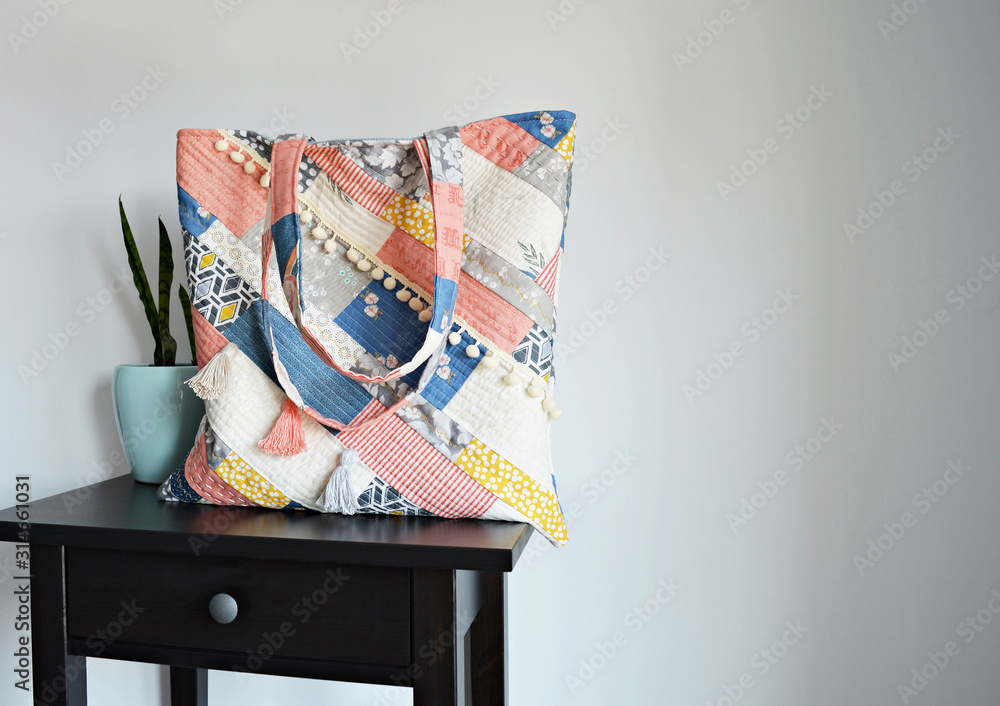 Obraz premium Quilted boho tote bag, house plant in mint pot and black table over white