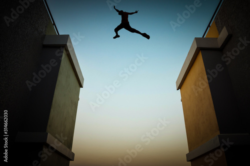 Concept of jumping over obstacles, The silhouette of a man jumping between two tall buildings.
