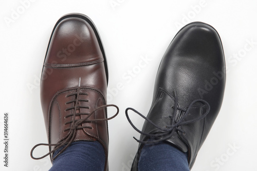 Men's feet in different color classic shoes on white background