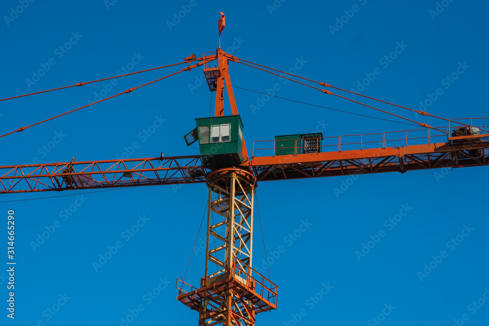 Tower crane against blue sky on a construction site for building of multi storage building or another type of structure. Tower crane against blue sky on a construction site for building of multi storage building or another type of structure.