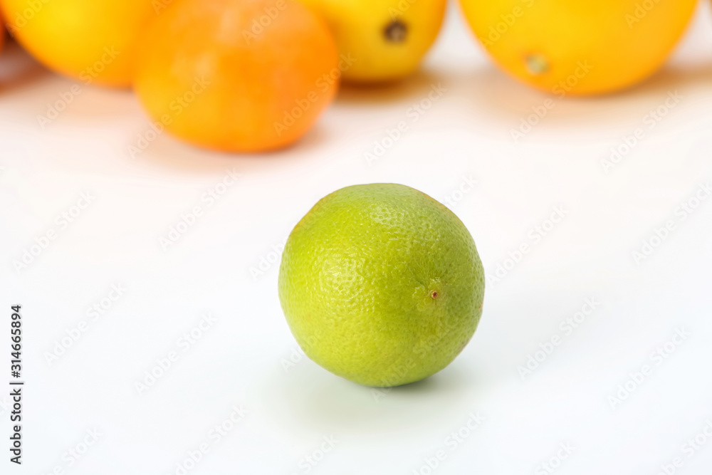 green lemon on the background of different citrus fruits on white background green lemon on the background of different citrus fruits on white background