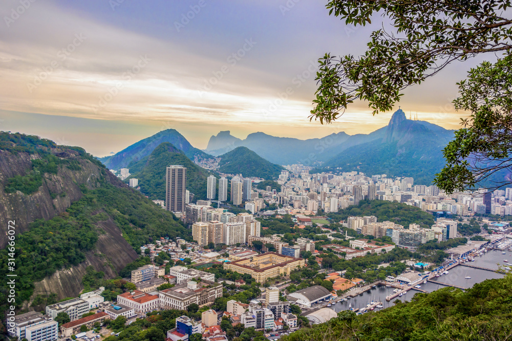 Obraz premium Rio De Janeiro Amazing View, Urca Hill, Sugar Loaf Mountain, Evening Clouds, Sunset. Buildings, City Center, Jesus Redeemer Statue, Ocean Coastline And Tropical Rainforest Hills In Brazil, Rio.
