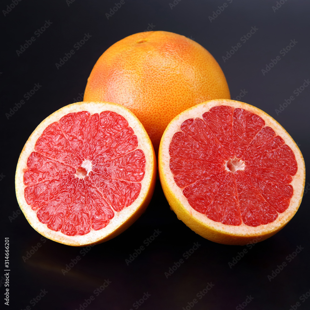 Citrus fruit. Sliced and whole grapefruit on a dark background Citrus fruit. Sliced and whole grapefruit on a dark background
