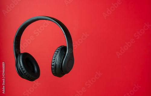 Black headphones on a red background. Minimal concept. photo