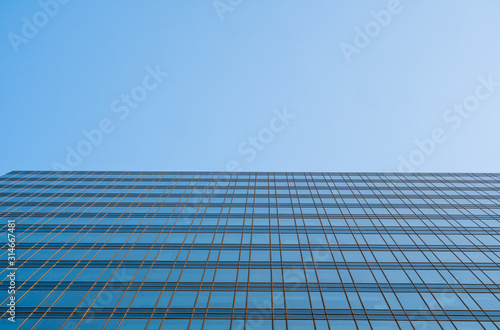 Reflection of the sky in the windows of a building. Perspective and underdite angle view to modern glass building skyscrapers over blue sky. Windows of Bussiness office or corporate building.