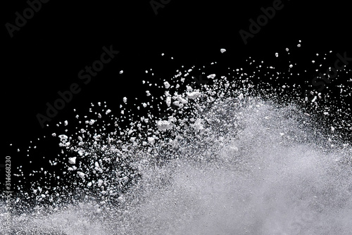 White powder explosion isolated on black background.