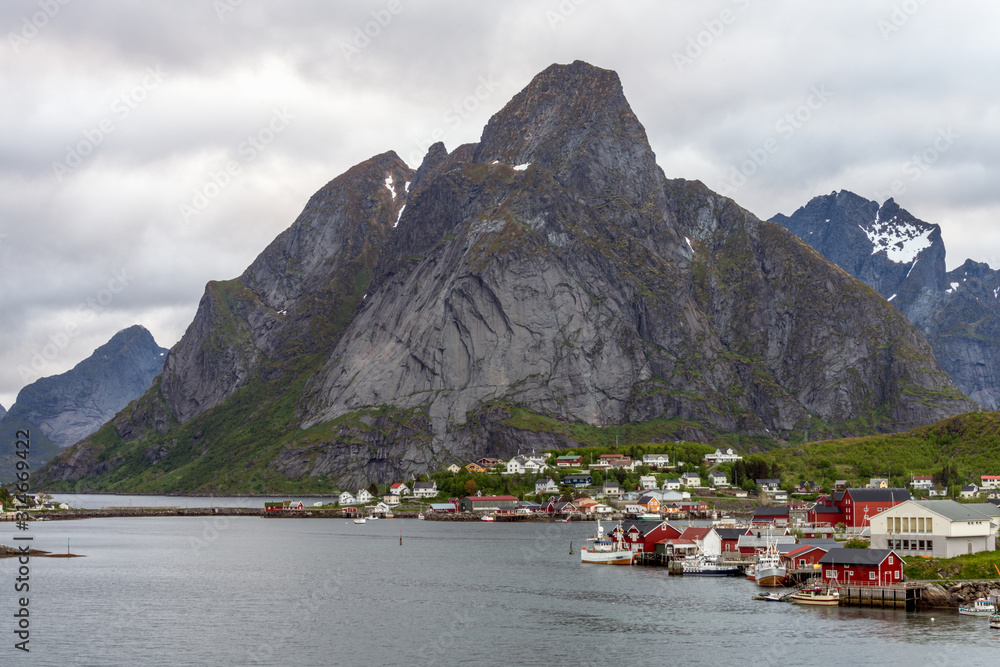 Aerial shot ofThe city of Reine in Lofoten/Norway. The famous Mount Olstind and snow covered mountains in the background. Traveling and Norwegian concept.