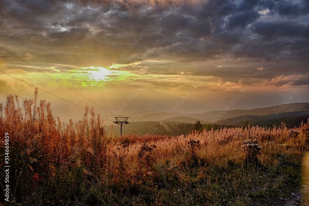 Sunset on ski slope in autumn mountains. Wonderful colors of nature and sky. Sunset on ski slope in autumn mountains. Wonderful colors of nature and sky.