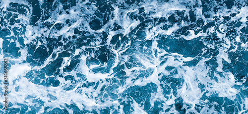 Aerial view of salt ocean waves. Blue water aqua sea background ot texture. Rippled spashing waves wide banner panoramatic photo.