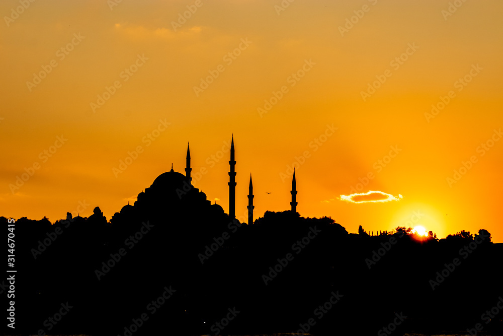 Sunset panorama of Istanbul at the golden hour, Sultan mosque visible as the sun goes down, golden yellow sky