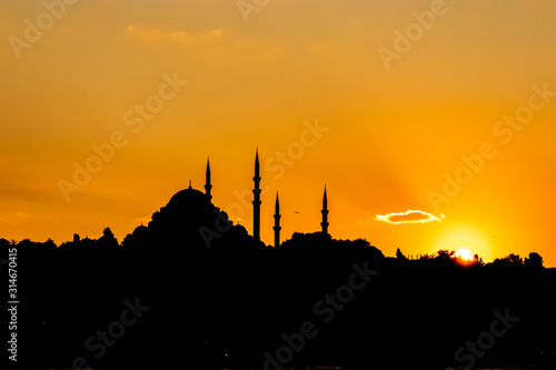 Sunset panorama of Istanbul at the golden hour, Sultan mosque visible as the sun goes down, golden yellow sky © Antonio