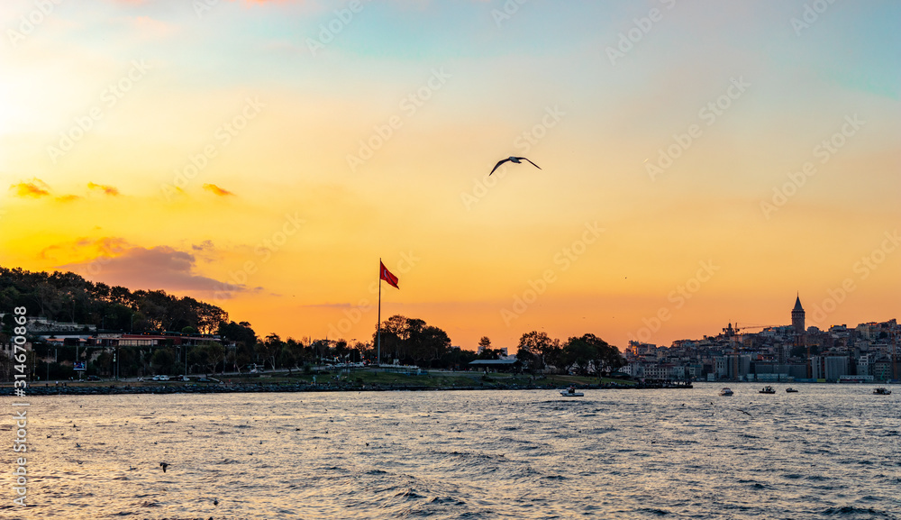 Turkish flag in Istanbul, Turkey. Waving in the wind with golden sky in the background as the sun goes behind the horizon
