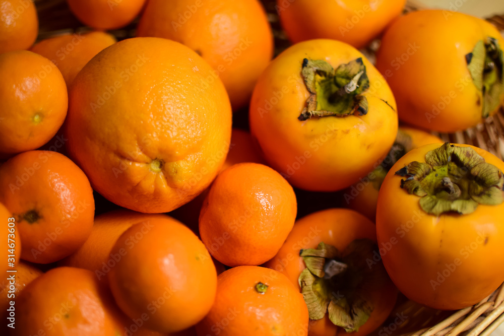 Orange fruits close-up. Oranges, tangerines and persimmons. Orange fruits close-up. Oranges, tangerines and persimmons.