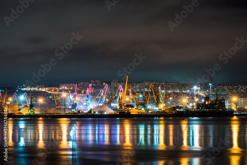 night Murmansk  city lights reflected in the Bay and the ships standing in the port