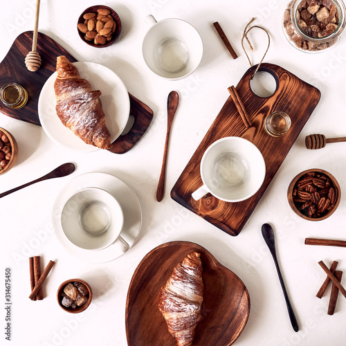 European breakfast, croissant cinnamon coffee, nuts, rekan, almonds, honey, spoon, wooden, top view, good morning, wake up concept, good morning. Top view. photo