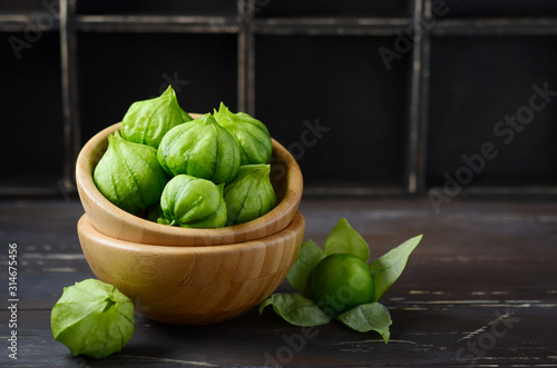 Fresh organic green tomatillos (Physalis philadelphica) with a husk on rustic wooden table. photo