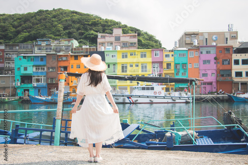 Keelung City, Taiwan. June. 29, 2019: Back view of woman traveling to The Pin Fishing Harbor- A landmark on the north coast of Taiwan. © JingLing