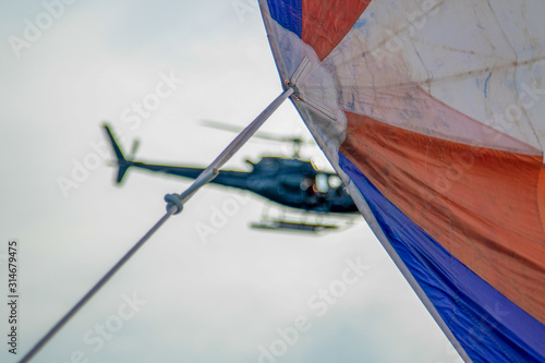 Un elicottero ripreso sullo sfondo di una vela