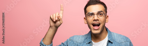 Panoramic shot of excited man showing idea sign isolated on pink © LIGHTFIELD STUDIOS