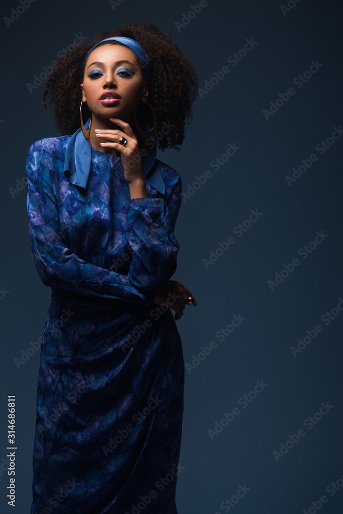 attractive african american woman looking at camera isolated on blue attractive african american woman looking at camera isolated on blue