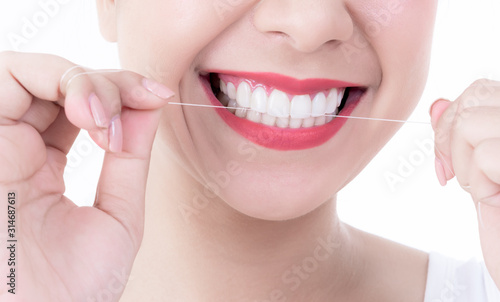 Close up images of young pretty woman  smiling  beautiful white and clean teeth  are using dental floss Clean teeth after eating For good dental health On white background to health care concept