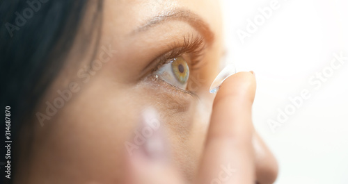 Young girl puts on contact lenses