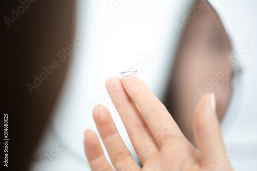 Young girl puts on contact lenses