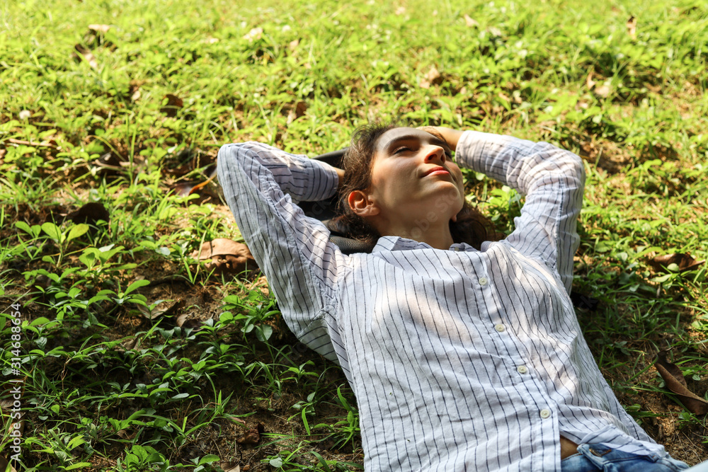 Beautiful woman sleeping relaxation on green grass in the garden. Beautiful woman sleeping relaxation on green grass in the garden.
