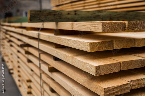 Piles of wooden boards in the sawmill  planking. Warehouse for sawing boards on a sawmill outdoors. Wood timber stack of wooden blanks construction material. Industry.