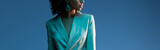  panoramic shot of african american woman in suit isolated on blue