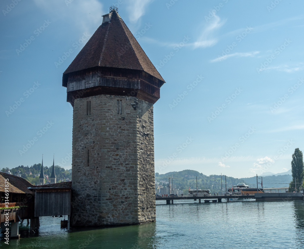 Charming scene of stone tower at Chapel bridge in Reuss river  on blue sky for backgrond with copy space, Luzern, Switzerland