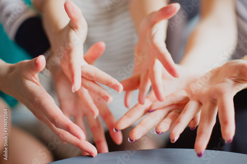  Several female hands reach for the camera.