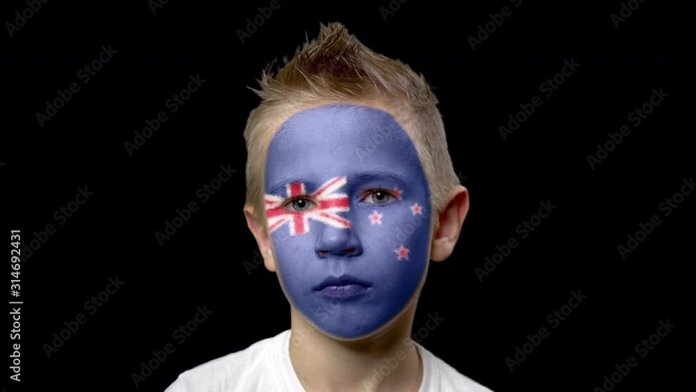 Sad fan of the football team of New Zealand. A child with a face painted in national colors. Unhappy boy with sad eyes. Fiasco of your favorite team. Disappointment. Sadness. Experience. Failure. Sad fan of the football team of New Zealand. A child with a face painted in national colors. Unhappy boy with sad eyes. Fiasco of your favorite team. Disappointment. Sadness. Experience. Failure.