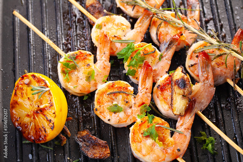 grilled shrimp on skewers. Grilled seafood on skewers with spices, herbs and lemon. delicious prawn. Grill. The iron grill. close up