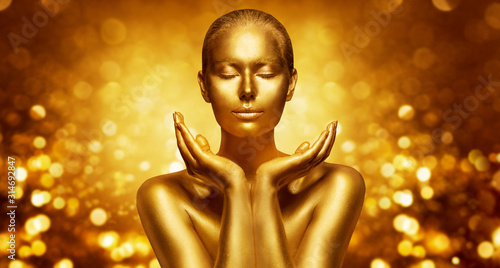 Gold Skin, Beautiful Woman holding Golden Beauty in Hands, Fashion Body Art Make Up