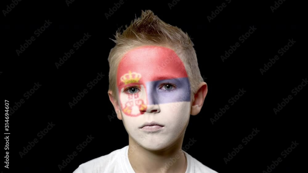 Sad fan of the football team of Serbia. A child with a face painted in national colors. Unhappy boy with sad eyes. Fiasco of your favorite team. Disappointment. Sadness. Experience. Failure. Bad luck. Sad fan of the football team of Serbia. A child with a face painted in national colors. Unhappy boy with sad eyes. Fiasco of your favorite team. Disappointment. Sadness. Experience. Failure. Bad luck.