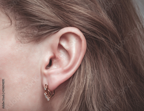 Fotografie Female ear with a golden earring