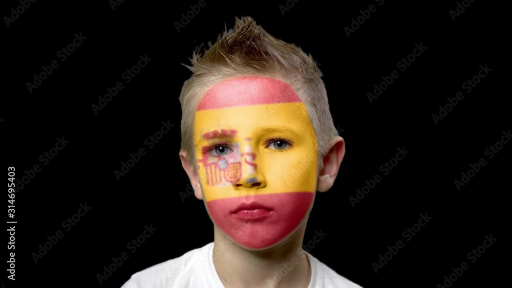 Sad fan of the football team of Spain. A child with a face painted in national colors. Unhappy boy with sad eyes. Fiasco of your favorite team. Disappointment. Sadness. Experience. Failure. Bad luck. Sad fan of the football team of Spain. A child with a face painted in national colors. Unhappy boy with sad eyes. Fiasco of your favorite team. Disappointment. Sadness. Experience. Failure. Bad luck.