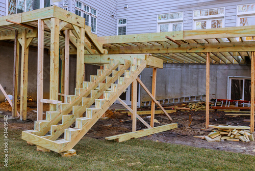 Installing deck boards with above ground deck, patio construction. photo