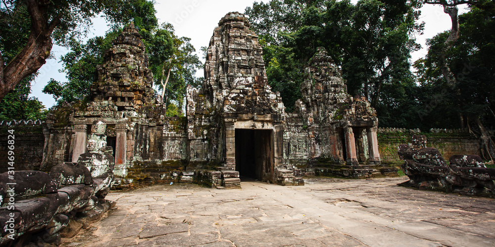 Fototapeta premium Temples of Angkor Wat where the jungle has partially overgrown the ruins near the city of Siem Reap in Cambodia