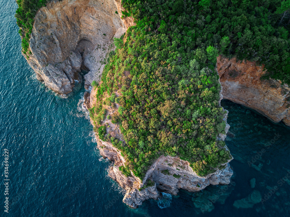 Aerial view of a steep cliff, unspoiled nature of the Montenegro coast. Sea caves and inlets alternate on the Mediterranean coast