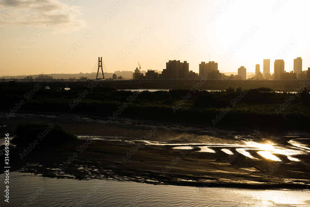 silhouette of buildings with river at sunset silhouette of buildings with river at sunset