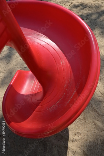 red slide for kid playing outdoor in sand playground