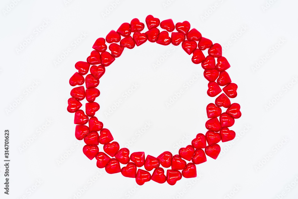 Obraz premium Bright red hearts are shiny, glass lie in the form of a round frame on a white background. Concept of love, marriage, wedding, Valentine's day, passion