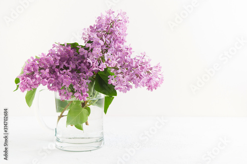 Branches of fresh purple lilac in glass vase