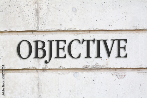 Written Objective word on concrete wall background