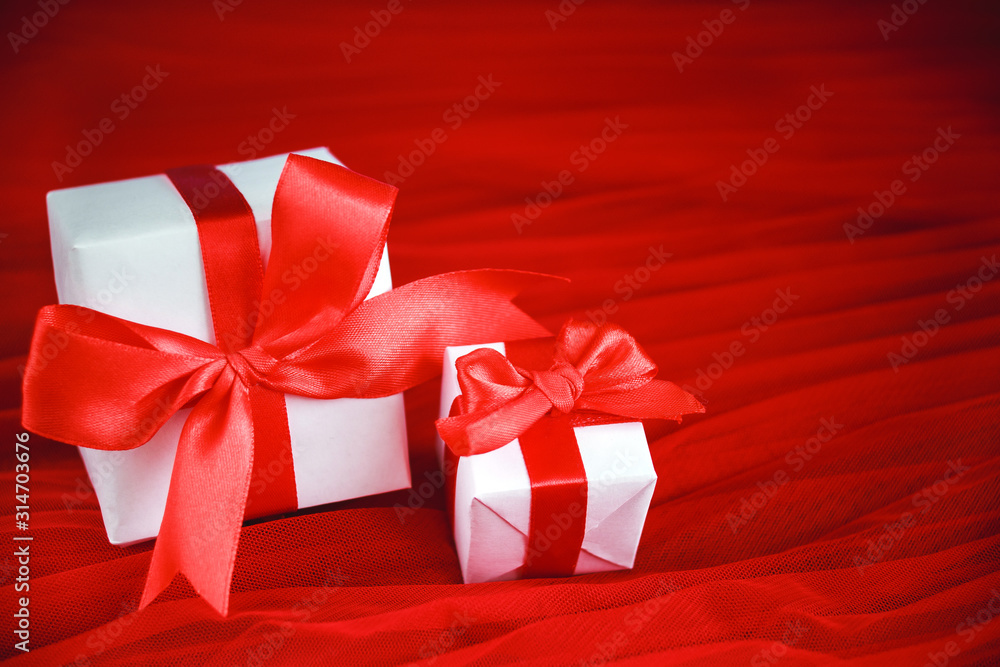 Holiday concept valentine's day. Two gifts in white wrapping paper on a red background. Layout with space for your text. Day of big discounts - sale. Holiday concept valentine's day. Two gifts in white wrapping paper on a red background. Layout with space for your text. Day of big discounts - sale.
