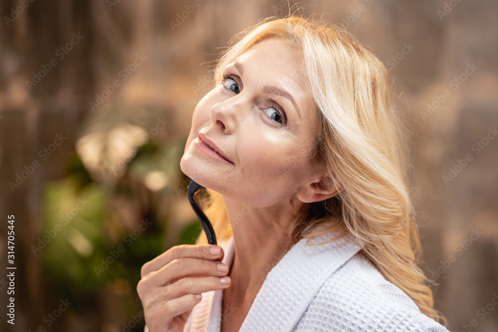 Tranquil pretty Caucasian female massaging her chin Tranquil pretty Caucasian female massaging her chin